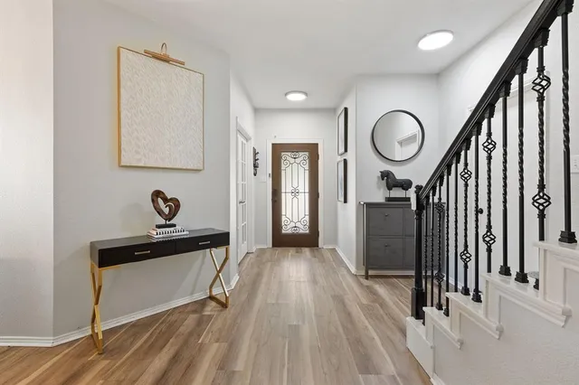 a view of a hallway with wooden floor and staircase