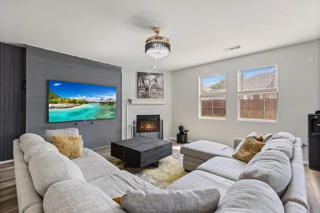 a living room with furniture a fireplace and a flat screen tv