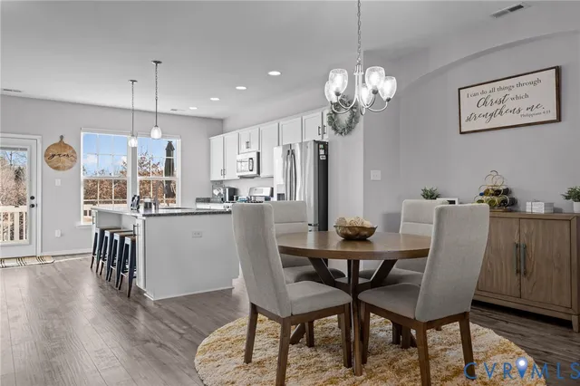 a dining room filled chandelier and wooden floor
