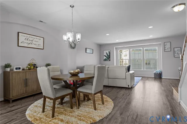 a dining room with furniture a chandelier and wooden floor