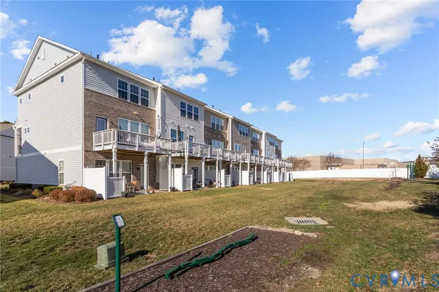 a view of residential houses with yard and lake view
