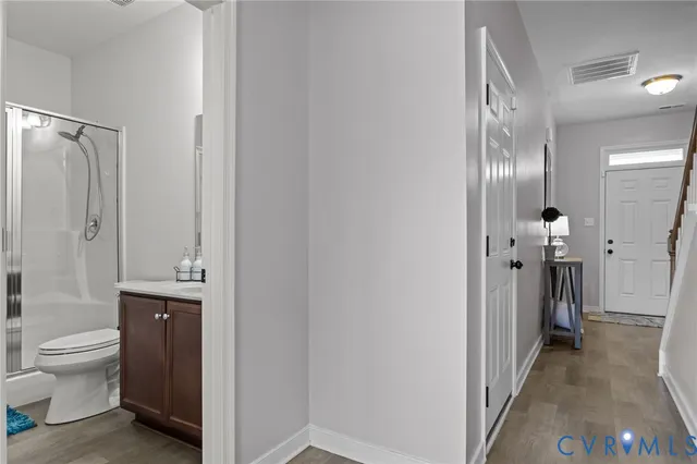 a bathroom with a granite countertop toilet a sink and a large mirror