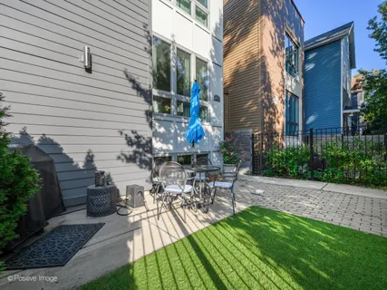 a view of a patio with table and chairs potted plants and large tree