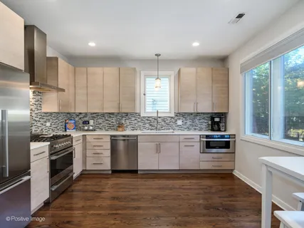 a kitchen with granite countertop white cabinets and stainless steel appliances