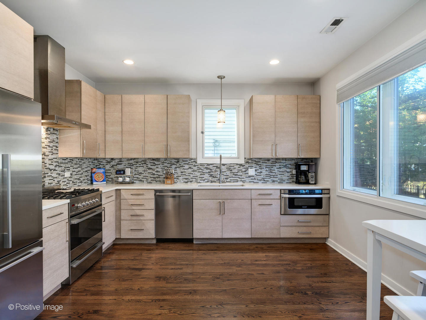 2139 North Bingham Street Chicago, IL 60647 - Photo 7 of 24 a kitchen with granite countertop white cabinets and stainless steel appliances