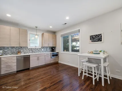 a kitchen with granite countertop kitchen island wooden floor and stainless steel appliances