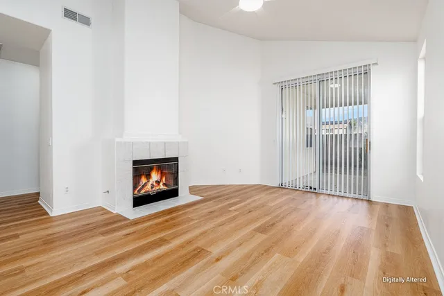 a view of empty room with wooden floor and fireplace