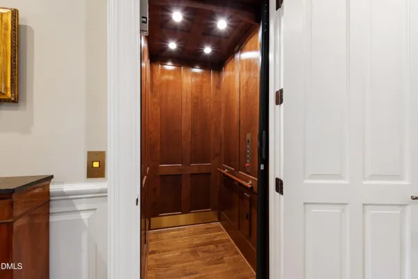 a front view of a house with a garden and tree