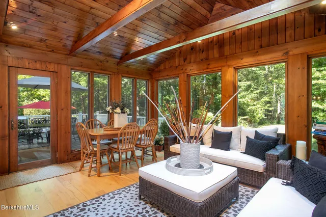 a view of a dining room and livingroom with furniture wooden floor a chandelier