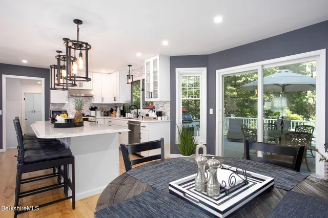 a bathroom with a granite countertop toilet a sink and a window
