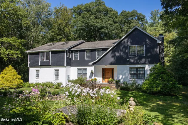 a front view of a house with a yard and trees