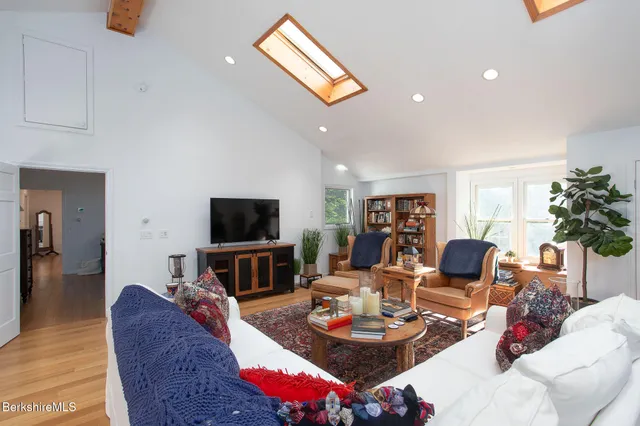 a living room with furniture a flat screen tv and kitchen view