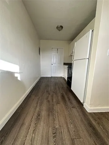 a view of a room with wooden floor and a sink