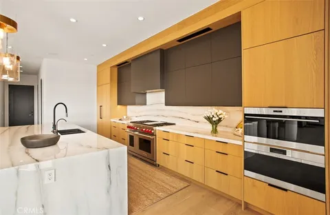 a kitchen with stainless steel appliances kitchen island granite countertop a stove a sink and white cabinets