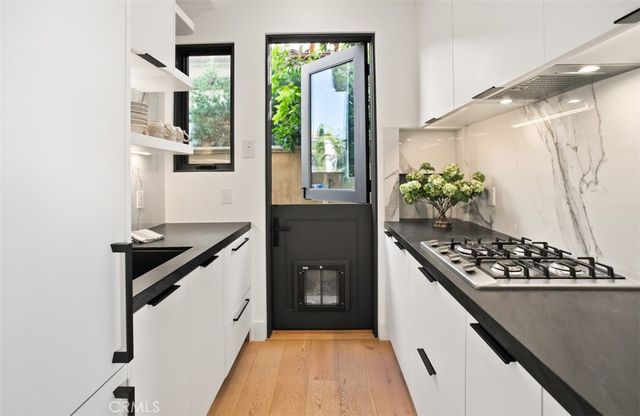 a kitchen with a stove and a wooden floor