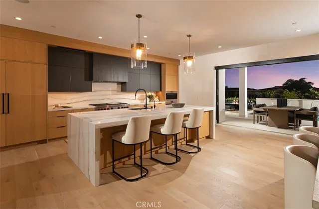 a kitchen with kitchen island a stove a table and chairs in it