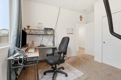 a view of a workspace with furniture and a window