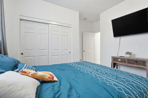 a bedroom with a bed and a flat screen tv