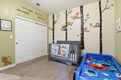 a bedroom with baby crib and a window