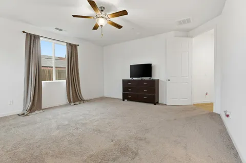 an empty room with windows and ceiling fan
