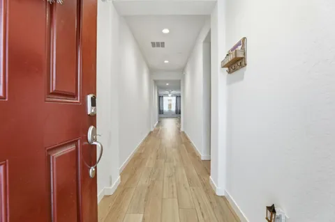 a view of a hallway with wooden floor and staircase