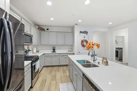 a kitchen that has a lot of cabinets a sink and appliances in it