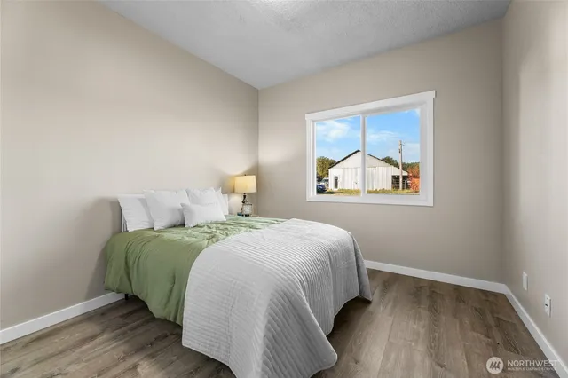a bedroom with a bed and wooden floor