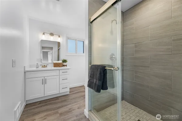 a bathroom with a sink a mirror and shower