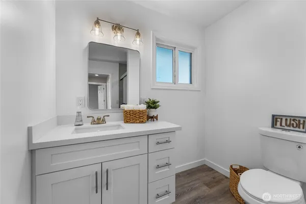 a bathroom with a toilet sink vanity and mirror
