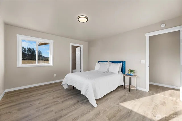 a bedroom with a bed and wooden floor