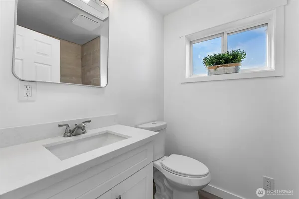 a bathroom with a sink a toilet and a mirror