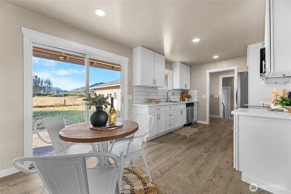 a kitchen with a dining table chairs and refrigerator