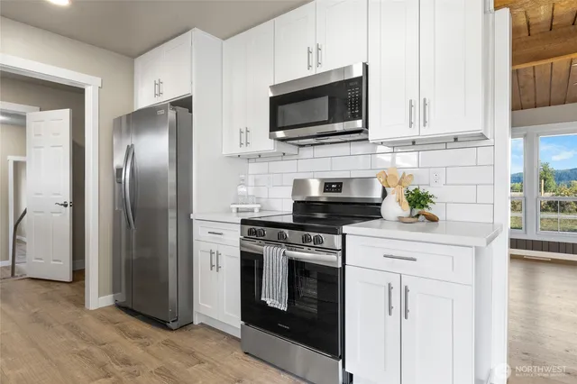 a kitchen with stainless steel appliances a stove microwave and sink