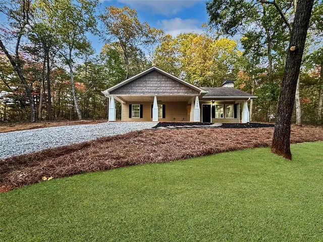 a front view of a house with a yard and trees