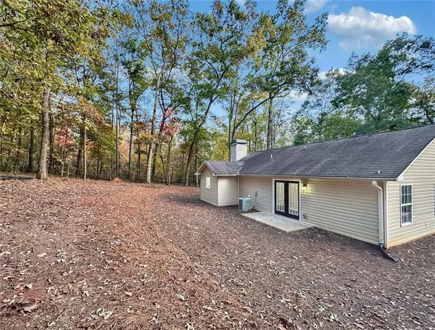 a view of a house with a yard and large tree