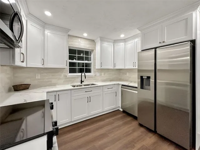 a kitchen with a refrigerator sink and cabinets
