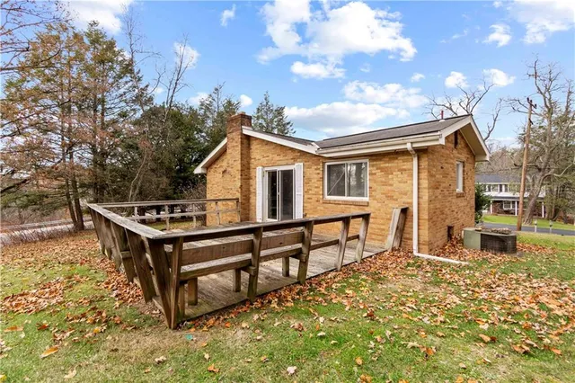 a view of a house with wooden deck and furniture