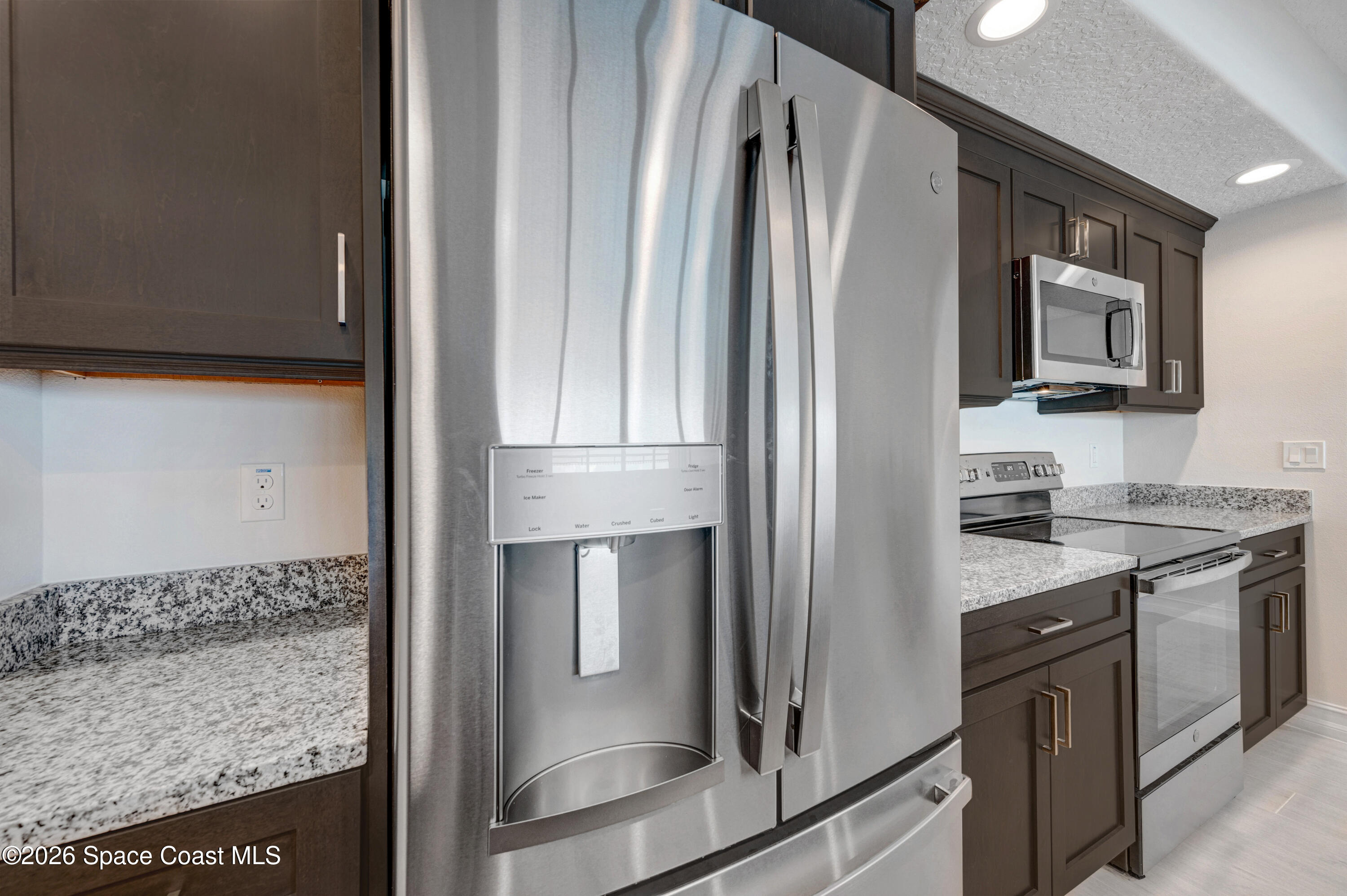 1805 Riverside Drive, Unit 304 Titusville, FL 32780 - Photo 25 of 46 a kitchen with stainless steel appliances granite countertop a refrigerator and a stove