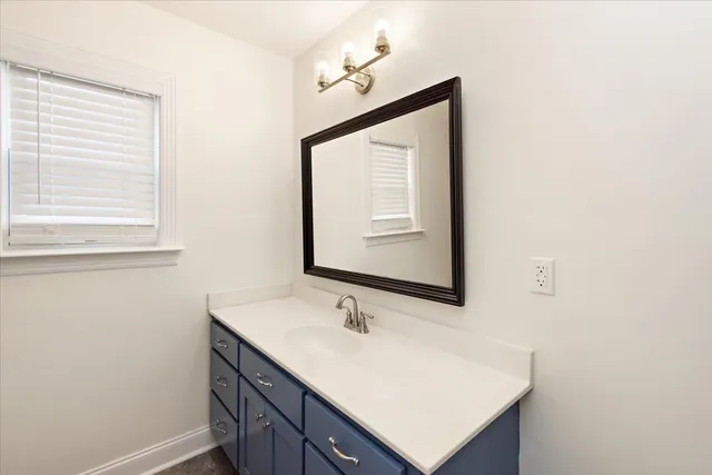 a bathroom with a sink vanity and a mirror