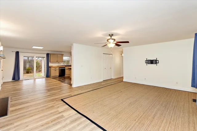 an empty room with wooden floor and chandelier