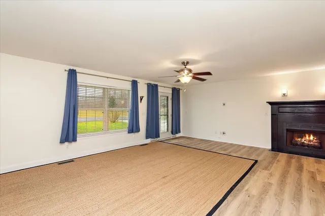a view of an empty room with a fireplace and a window