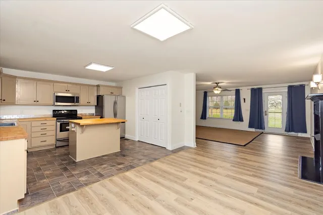 a large kitchen with cabinets wooden floor and stainless steel appliances