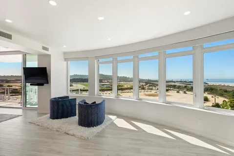 a living room with furniture tv and large windows