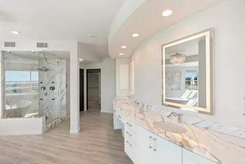 a bathroom with a granite countertop sink mirror and shower
