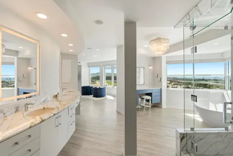 a large white kitchen with a large window and stainless steel appliances