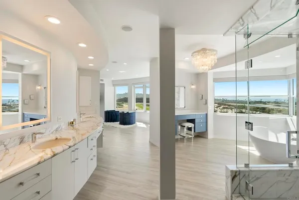 a large white kitchen with a large window and stainless steel appliances