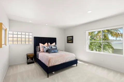 a bedroom with a bed and a large window