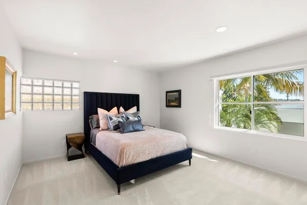 a bedroom with a bed and a large window