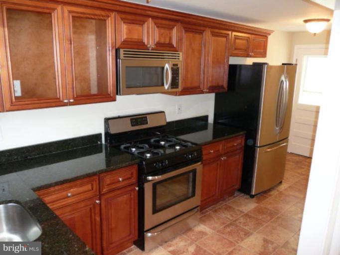 4502 Morgan Road Suitland, MD 20746 - Photo 7 of 14 a kitchen with granite countertop stainless steel appliances and wooden cabinets