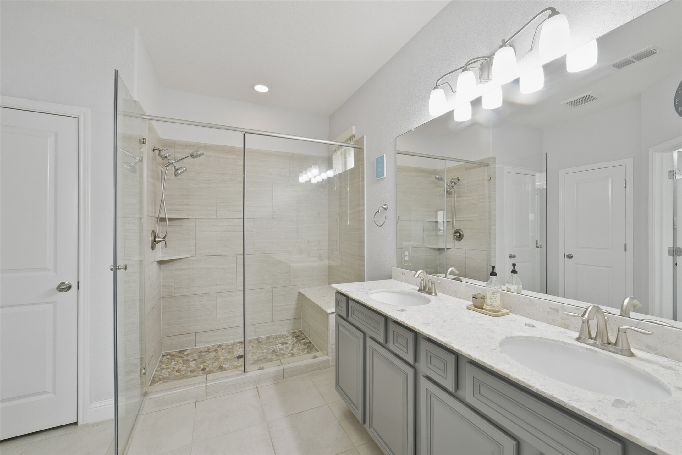 30014 Valley Terrace Drive Fulshear, TX 77406 - Photo 23 of 36 Just like the spa, you will love this primary ensuite bathroom! It showcases double sinks, tile floors, walk-in closet, a large walk-in standing shower with tile surround a seamless glass door.